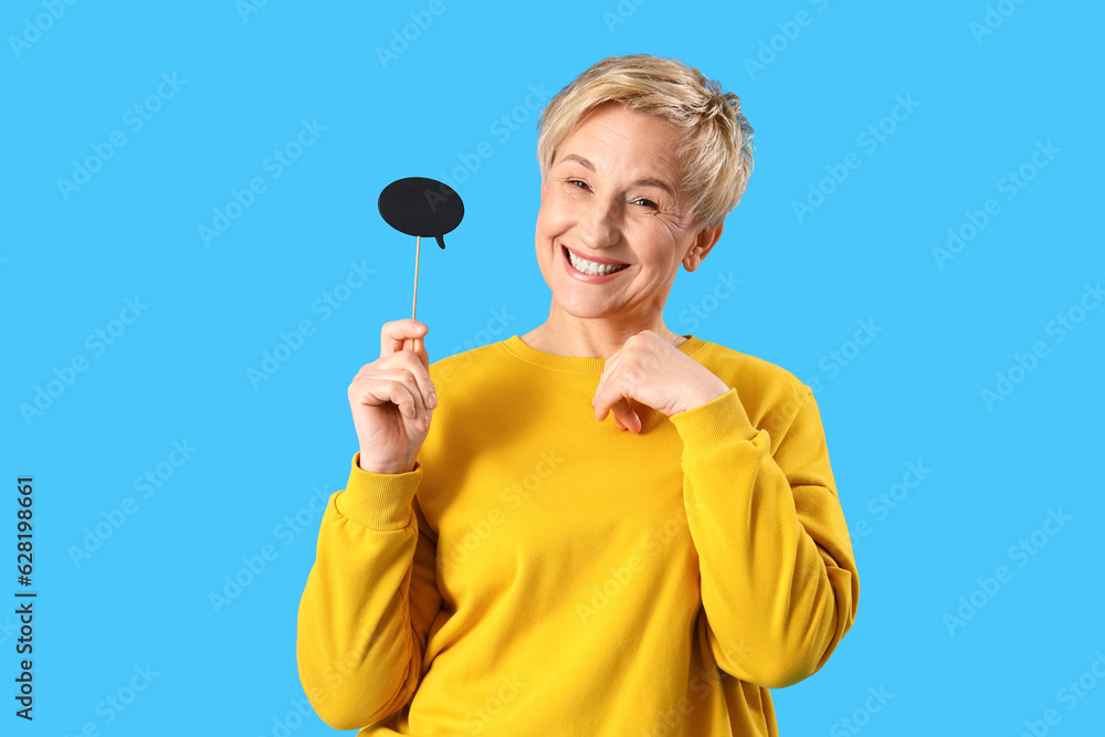 Happy mature woman with speech bubble on blue background