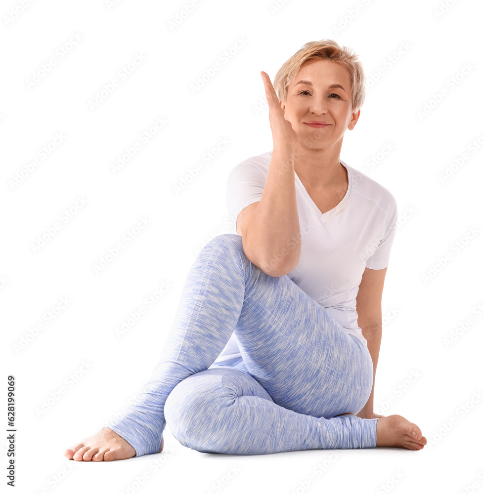 Sporty mature woman practicing yoga on white background