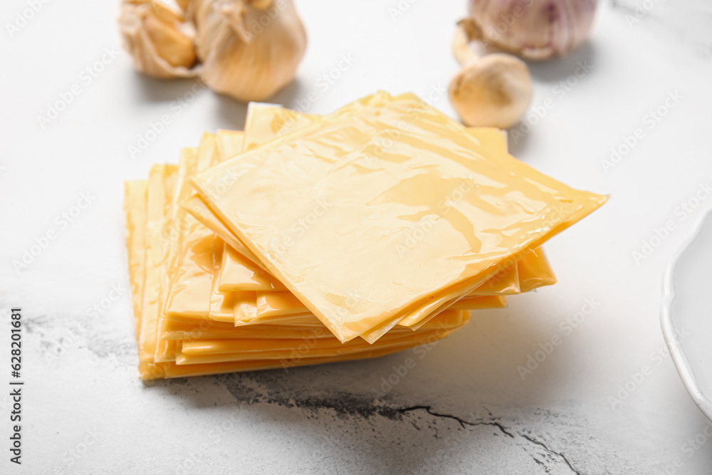 Slices of tasty processed cheese on white marble background