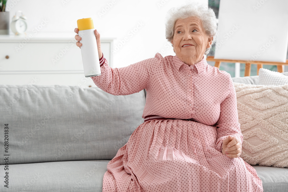 Senior woman with air freshener at home