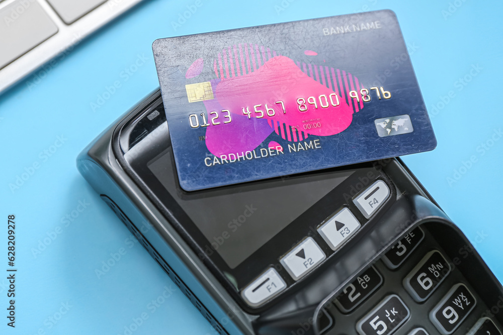 Payment terminal and credit card on blue background