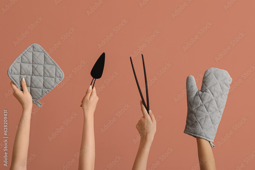 Female hands with baking utensils on pink background