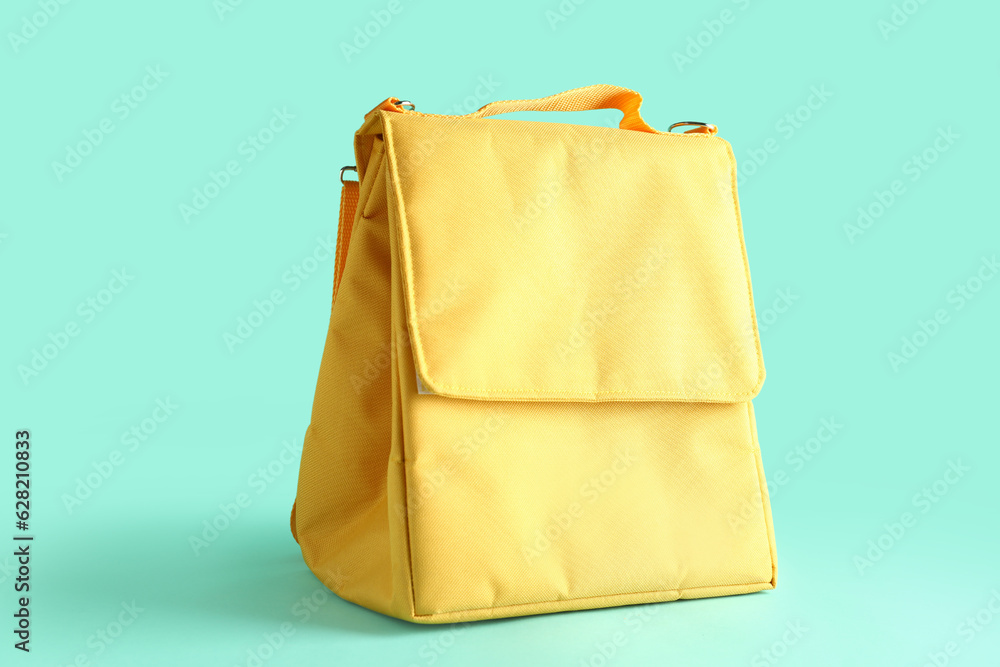 Yellow lunch box bag on turquoise background