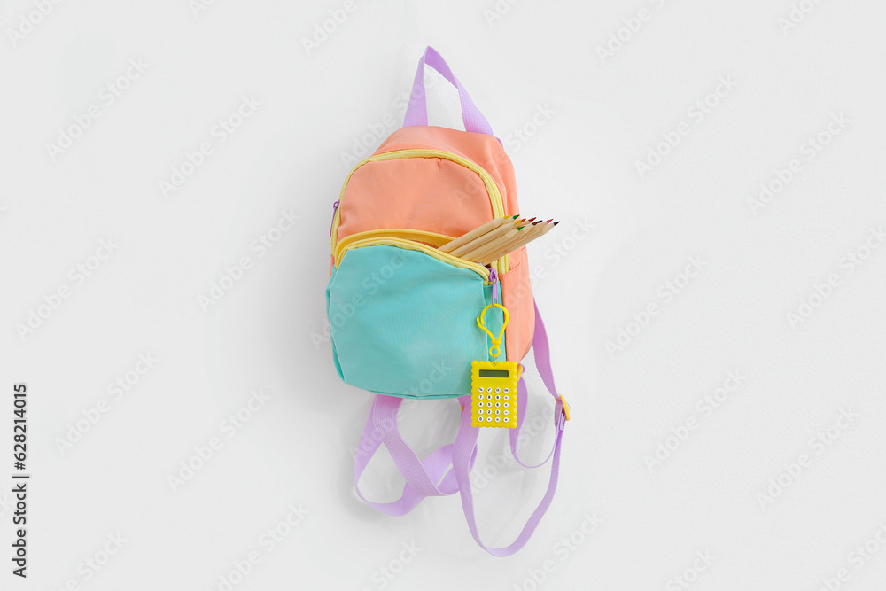 Color school backpack with stationery on white background