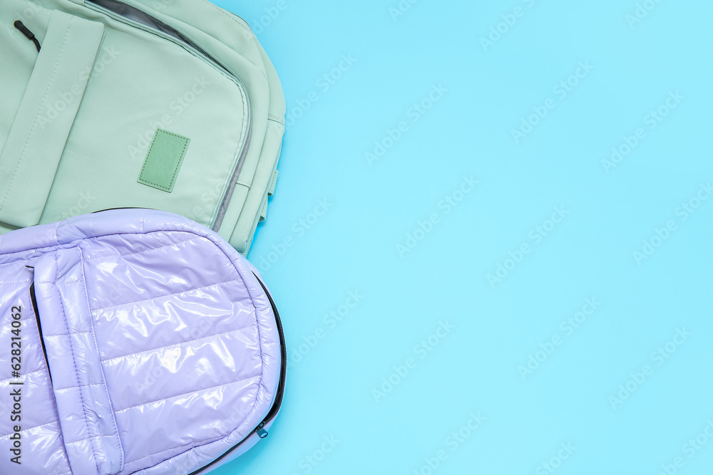 Color school backpacks on blue background