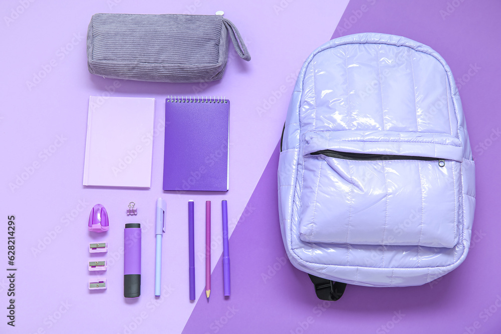 Lilac school backpack with stationery on color background