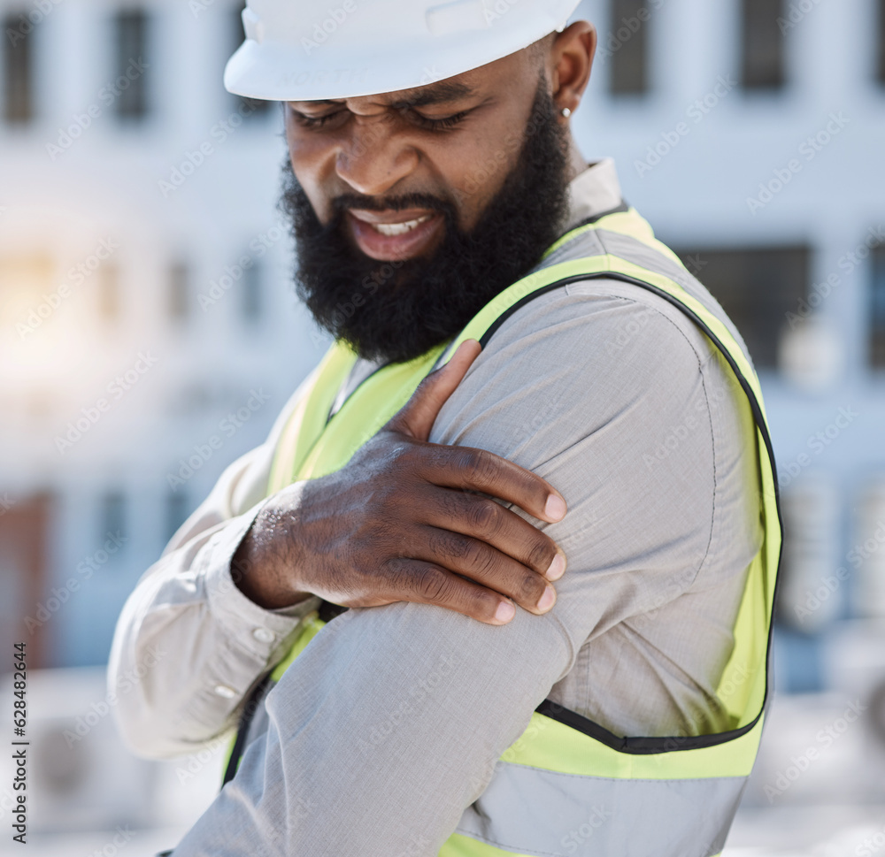 Injury, arm pain and a black man construction worker on a building site, feeling fatigue in his shou