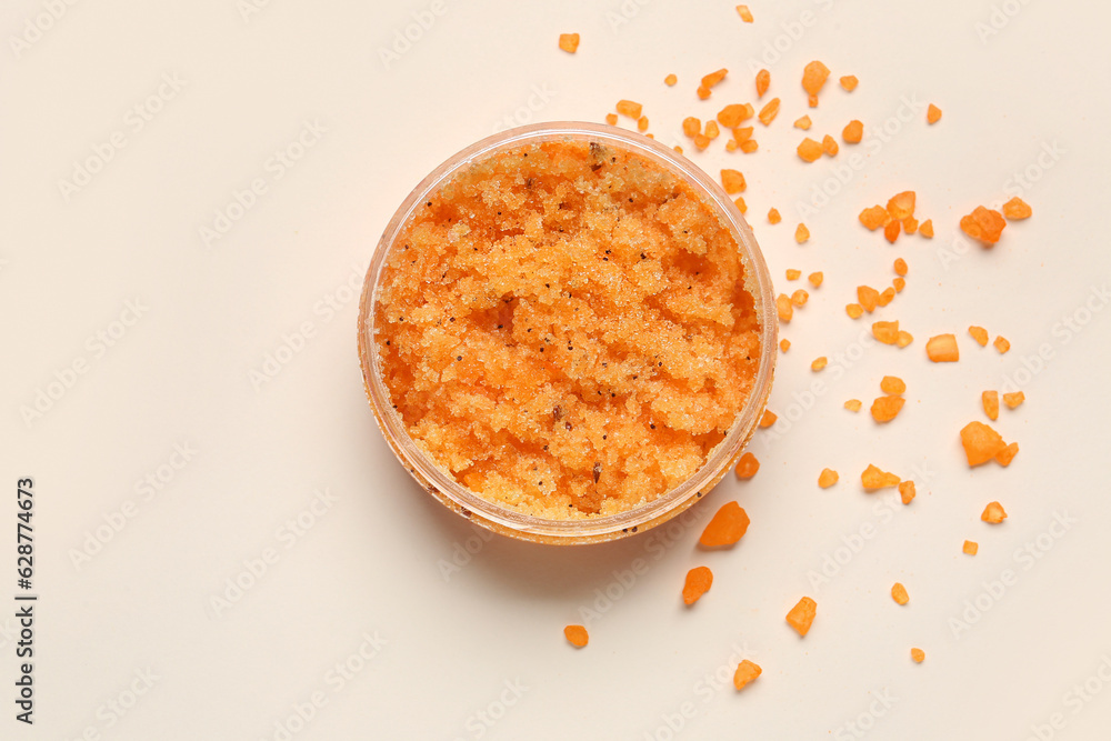 Jar of body scrub and sea salt on light background