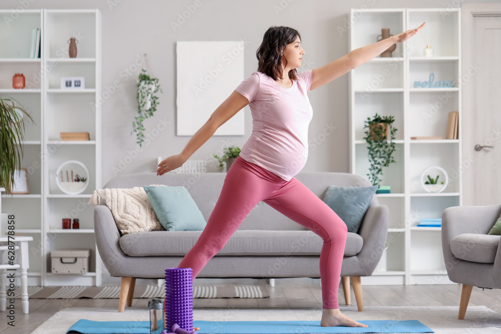 Sporty pregnant woman training at home