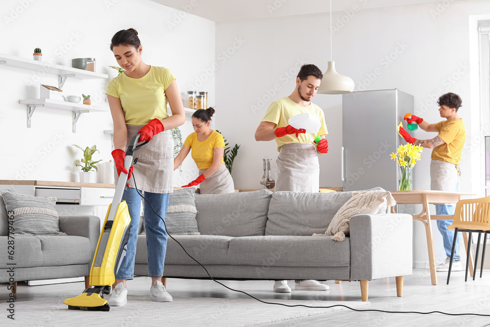 Young janitors cleaning in kitchen