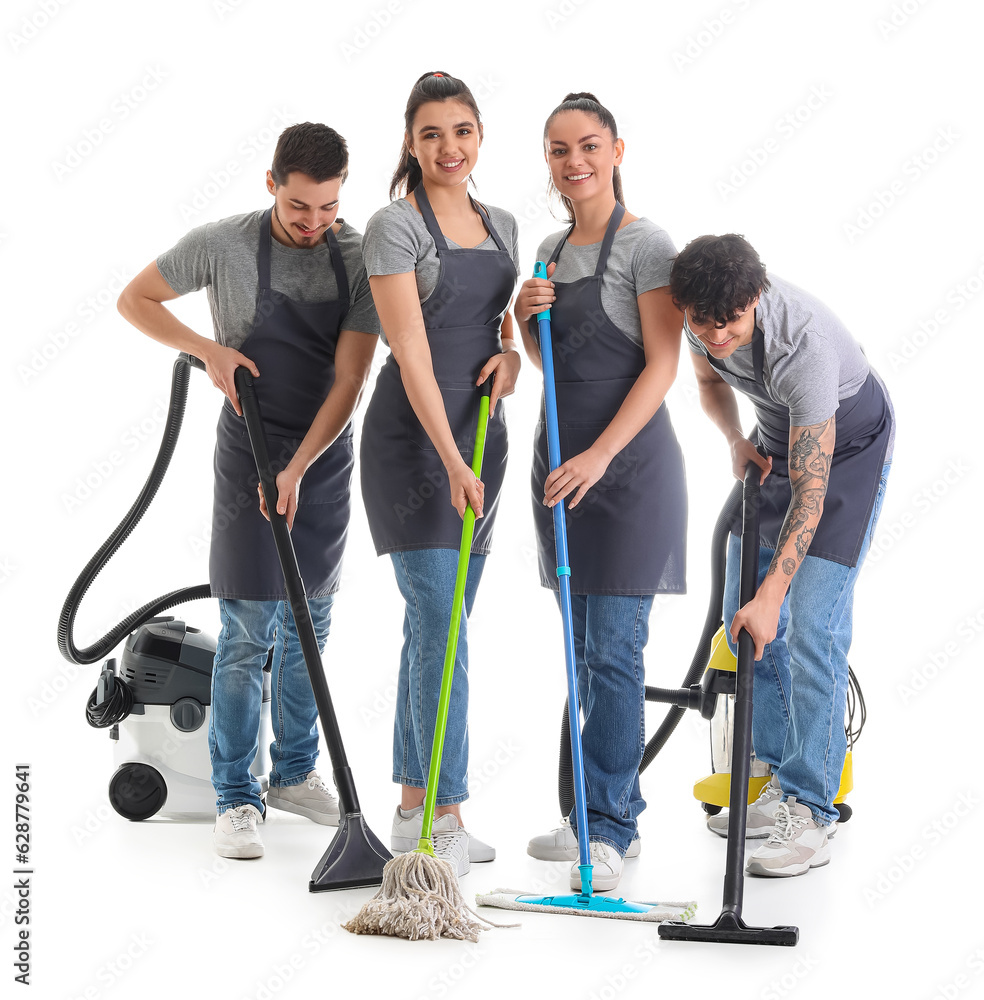 Young janitors with cleaning supplies on white background