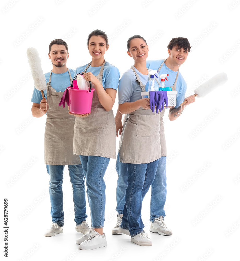 Young janitors with cleaning supplies on white background