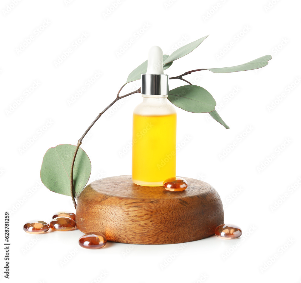 Bottle with cosmetic oil on wooden stand, eucalyptus branch and stones on white background