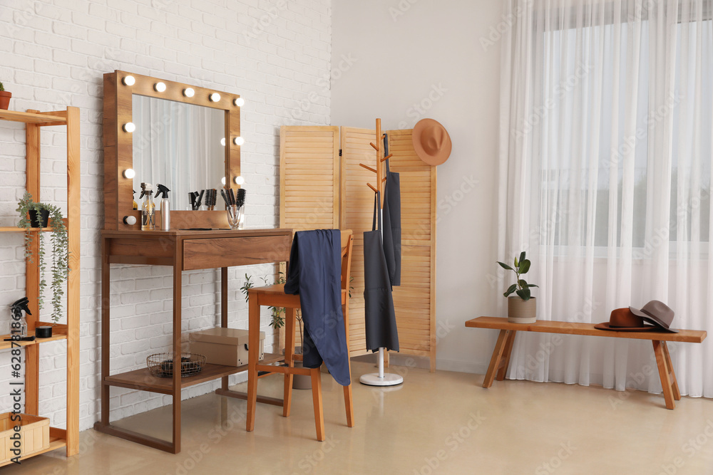 Interior of beauty salon with stylish table and folding screen