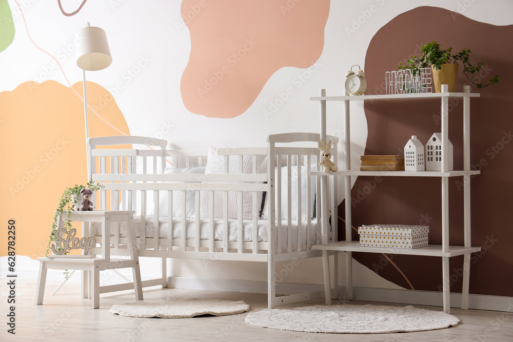 Interior of stylish bedroom with baby crib and shelving unit