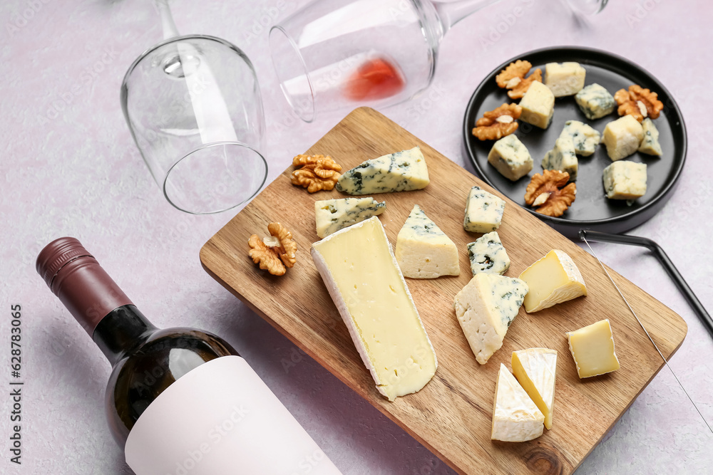 Pieces of tasty cheese, glasses and bottle with wine on light background