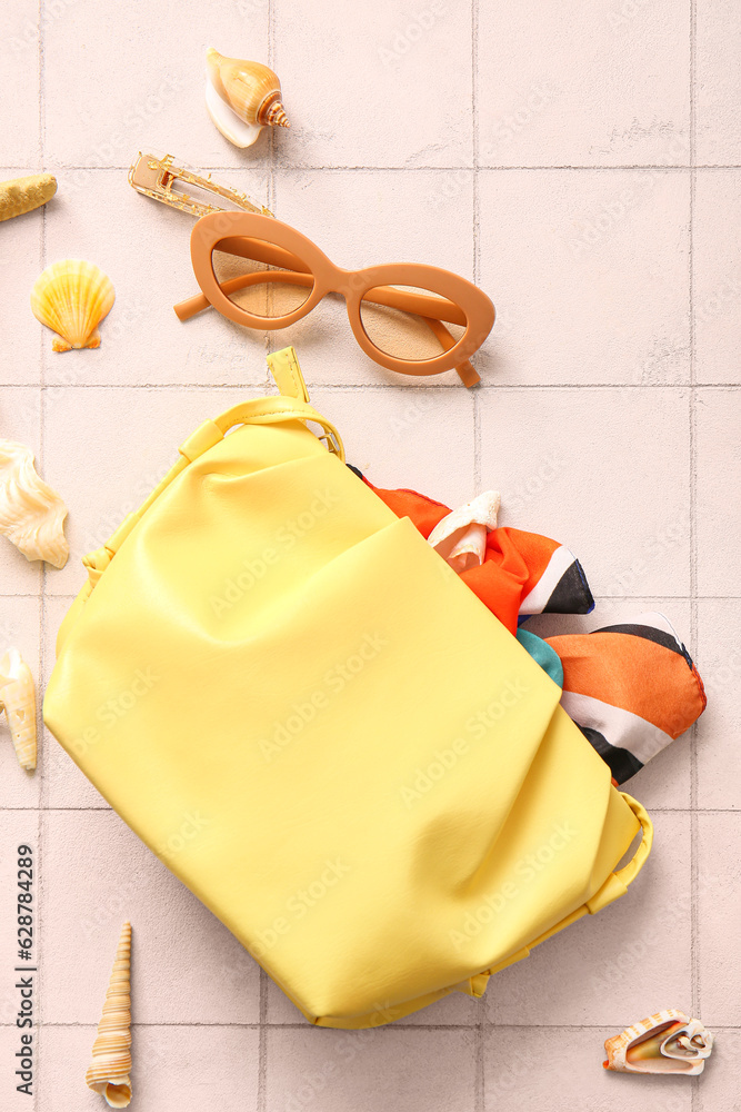 Stylish bag and sunglasses on white tile background