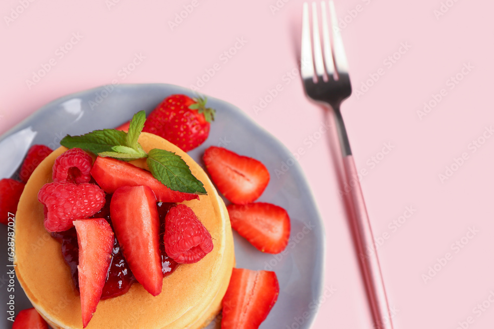 Plate with sweet pancakes and berries on pink background, closeup