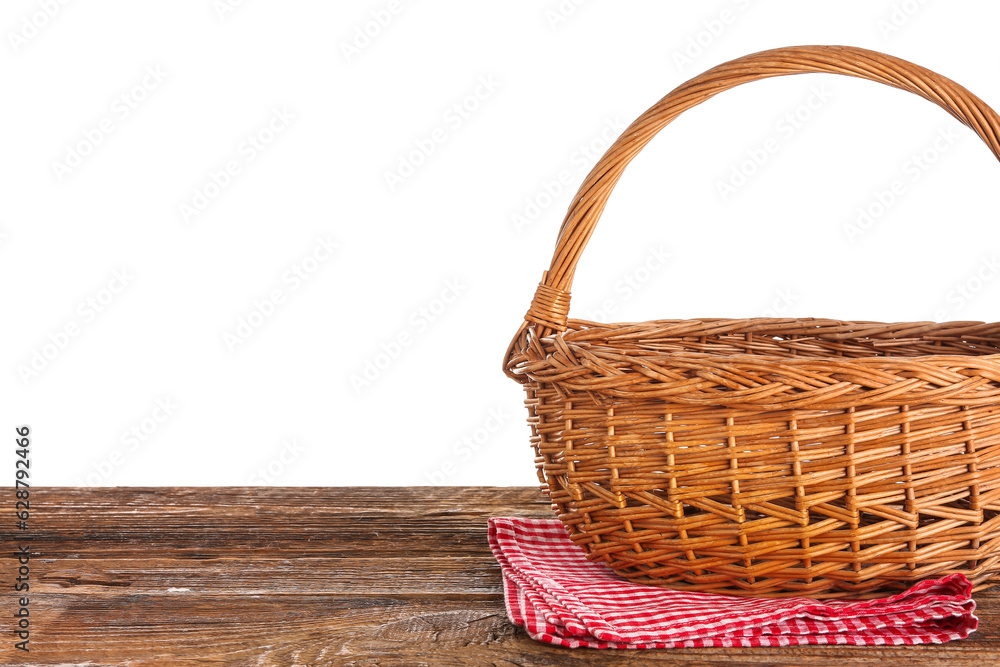 Wicker picnic basket and napkin on wooden table against white background