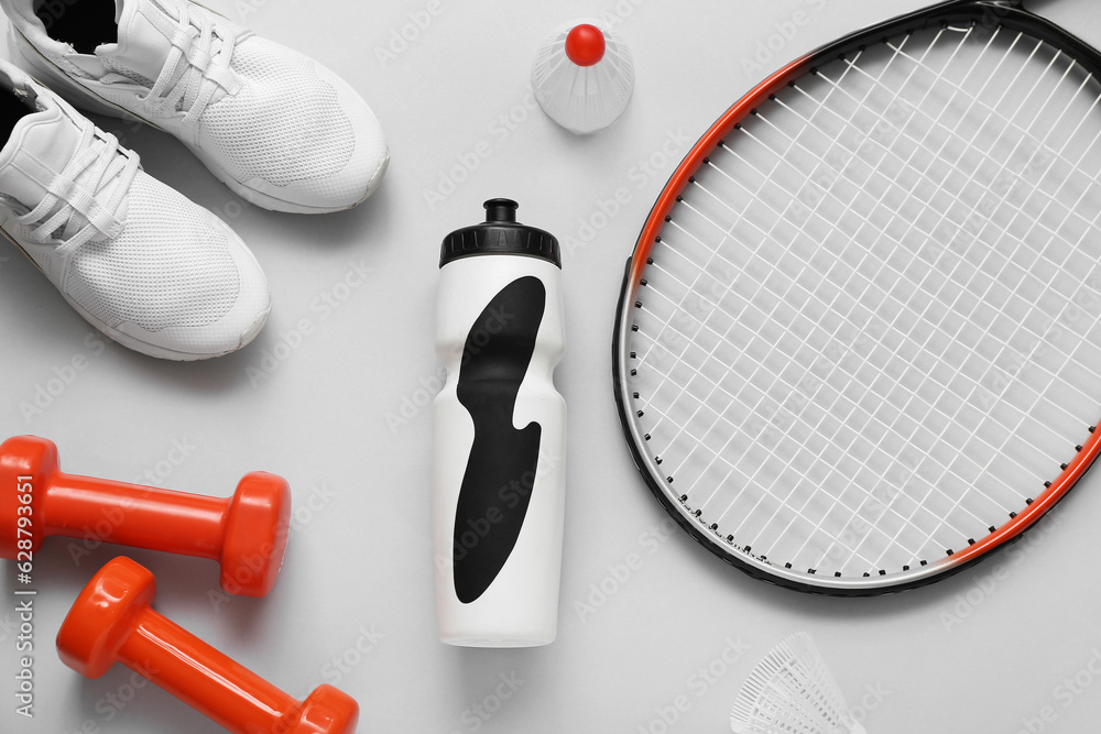 Set of sports equipment, shoes and bottle of water on light background