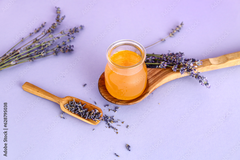 Jar of sweet lavender honey and flowers on lilac table