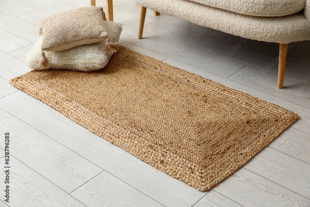 Wicker carpet with cushions in interior of living room, closeup