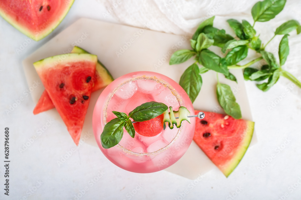 Board with glass of tasty watermelon cocktail and mint on white background