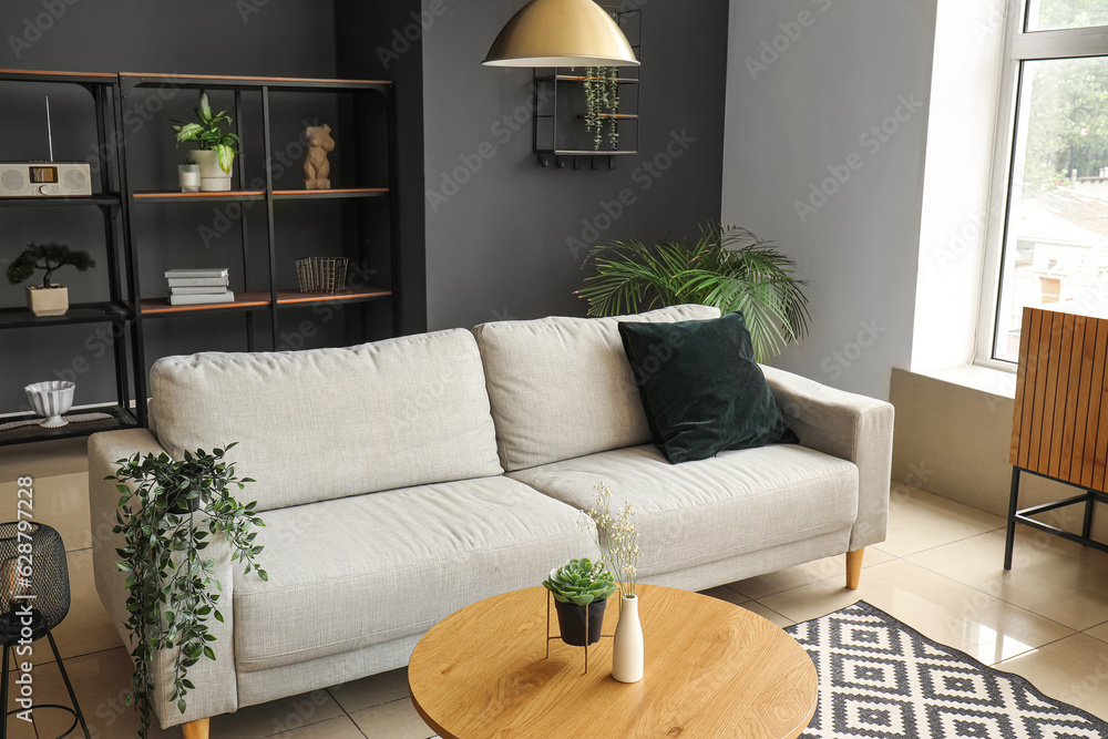 Interior of modern living room with comfortable grey sofa and wooden coffee table