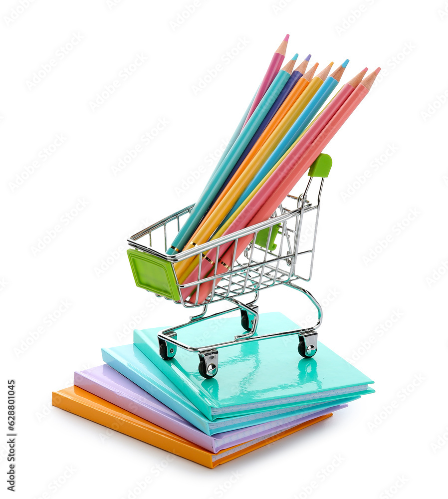 Notebooks and shopping cart with school stationery on white background