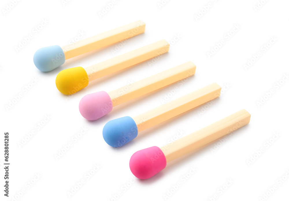 Set of erasers in shape of colorful matches on white background