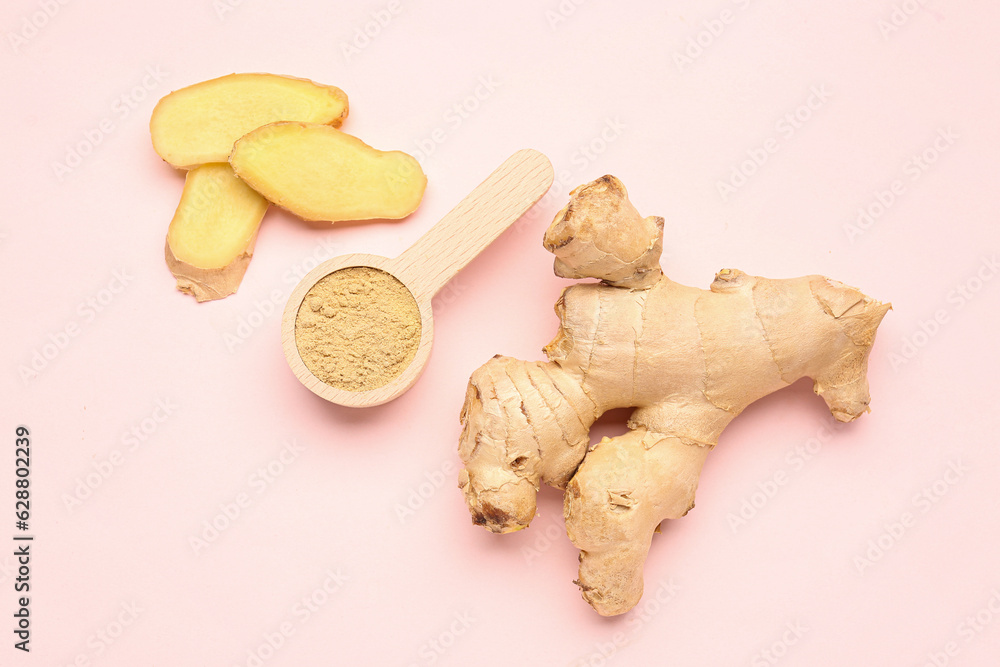 Fresh ginger root and wooden spoon with dried powder on pink background