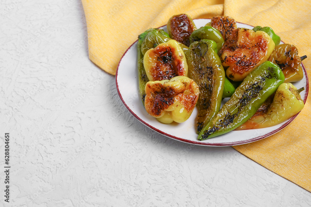 Plate with different grilled peppers on grey background