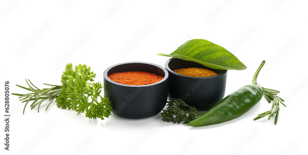 Bowls with spices and fresh herbs isolated on white background