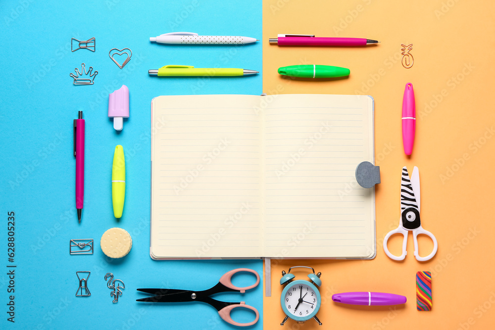 Notebook with different stationery supplies on colorful background