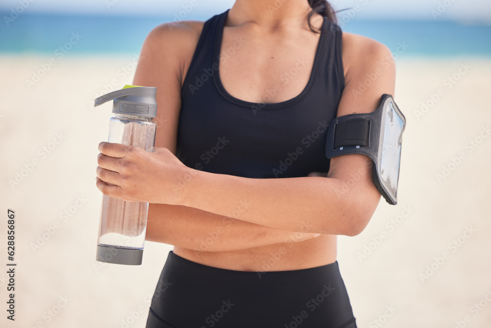 Woman, fitness and water with arms crossed on beach for workout, exercise or natural outdoor nutriti