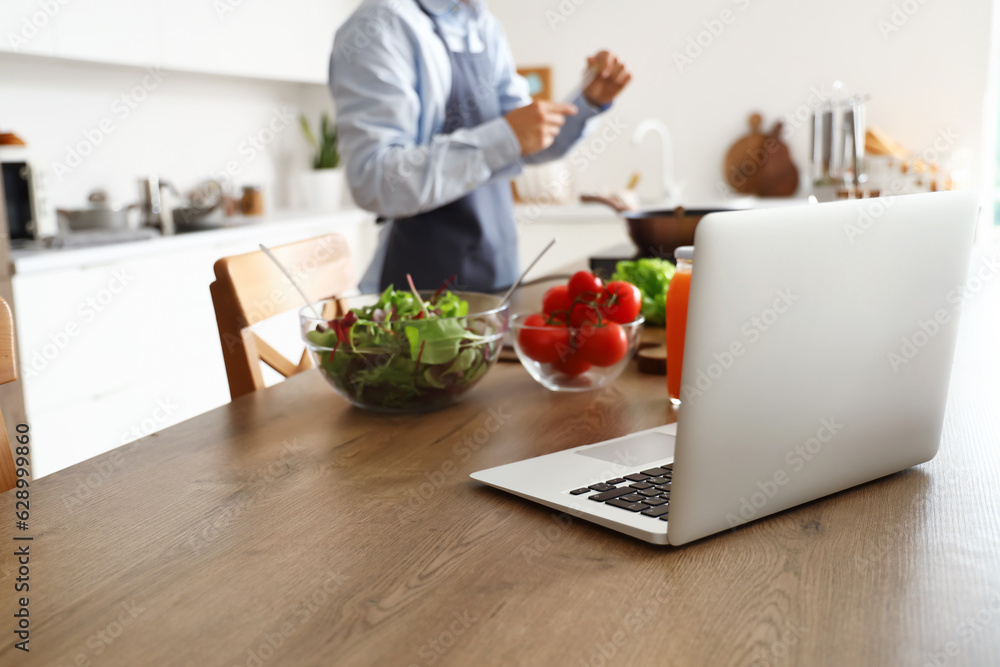 Laptop on table in kitchen, closeup