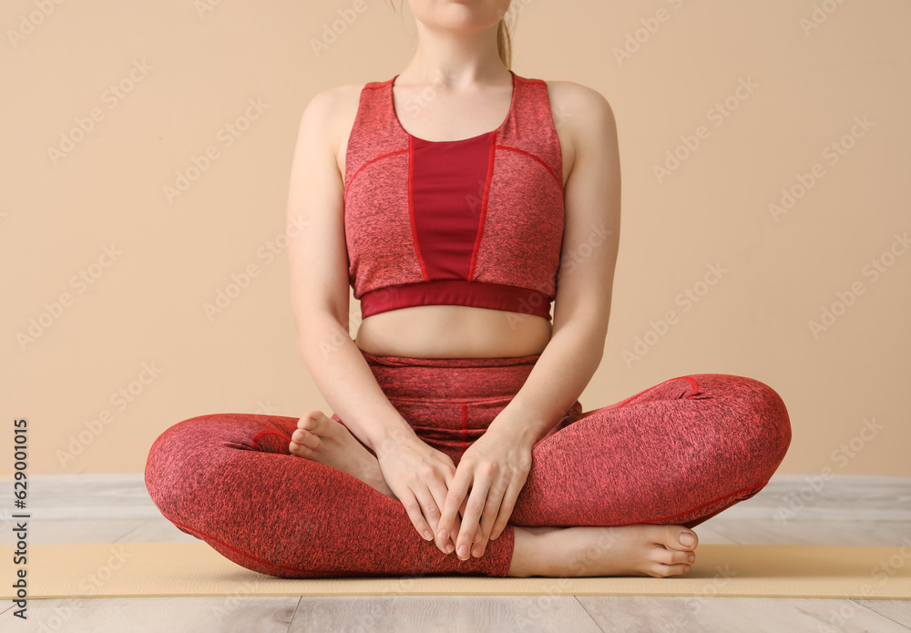 Young woman in sportswear doing yoga in gym