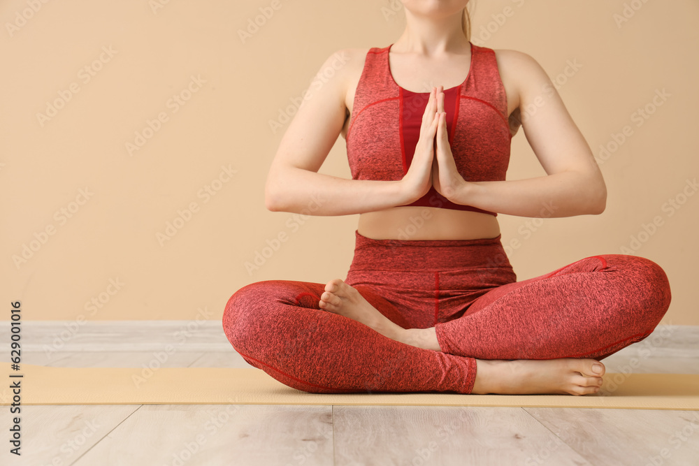 Young woman in sportswear doing yoga in gym