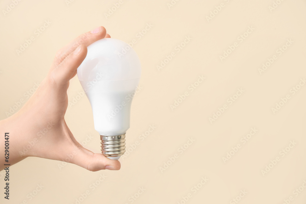 Woman with light bulb on beige background