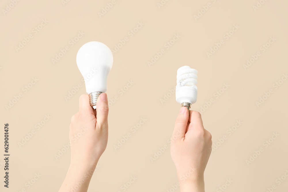 Woman with light bulbs on beige background