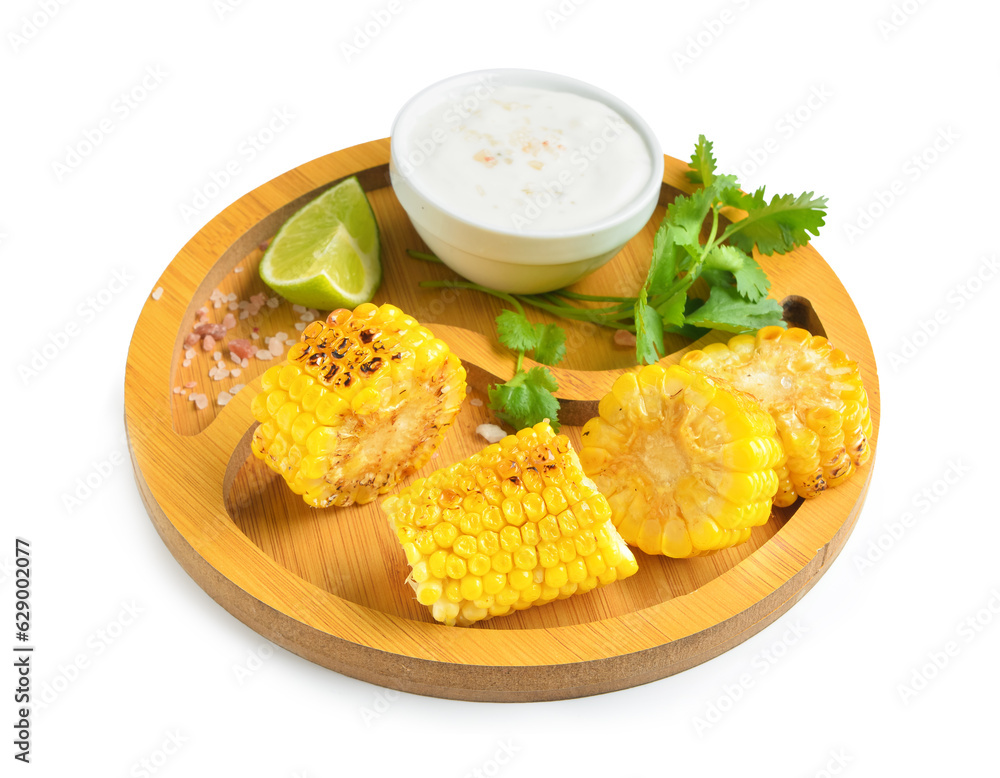 Wooden board with cut tasty grilled corn cob and sauce on white background