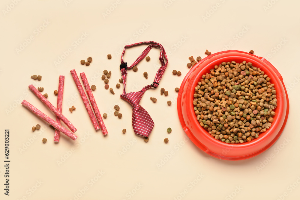 Composition with dry dog food, treats and necktie on color background