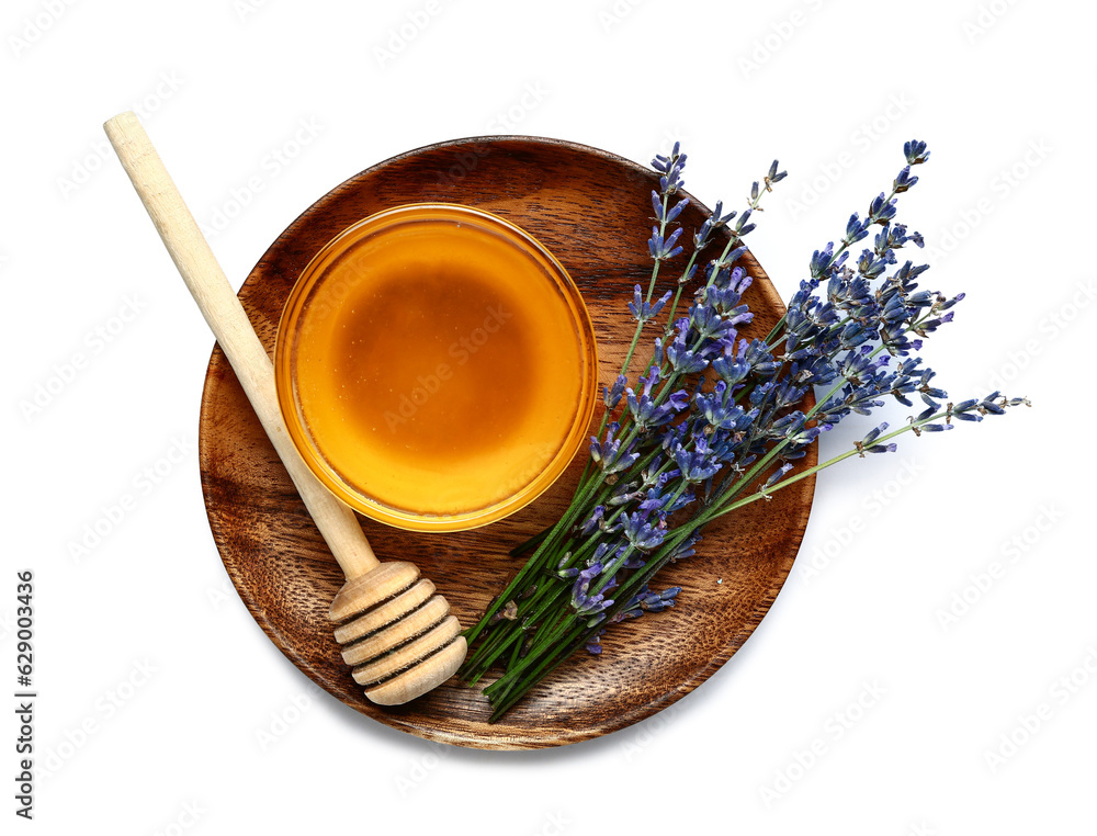 Plate with glass bowl of sweet lavender honey, dipper and flowers on white background