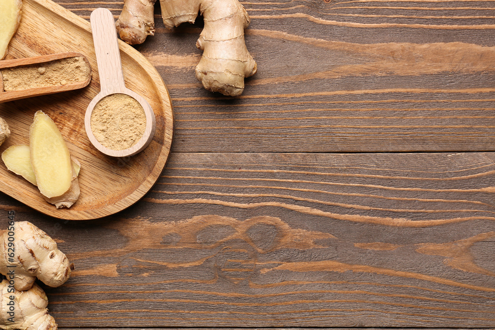 Fresh ginger roots, spoon and scoop with dried powder on wooden background