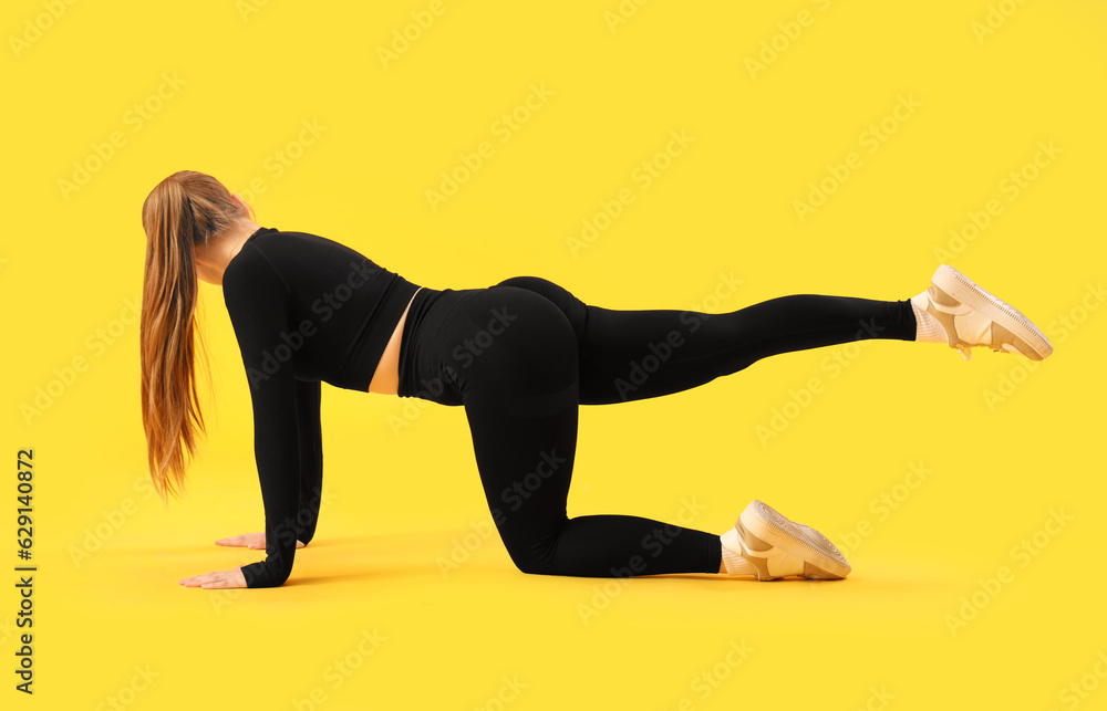 Young woman in sportswear on yellow background