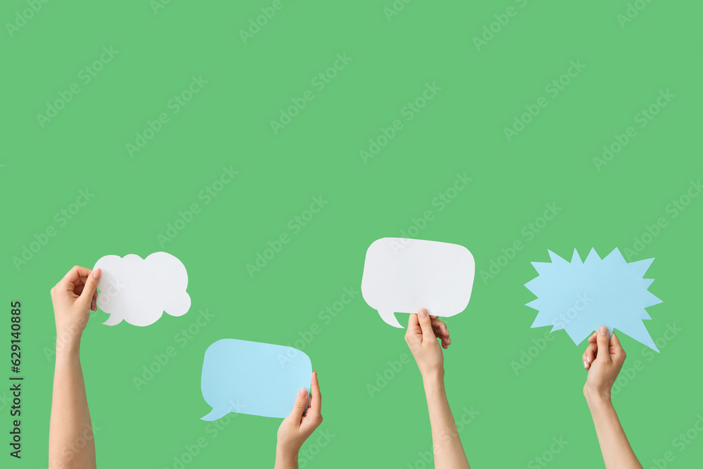 Female hands with speech bubbles on green background