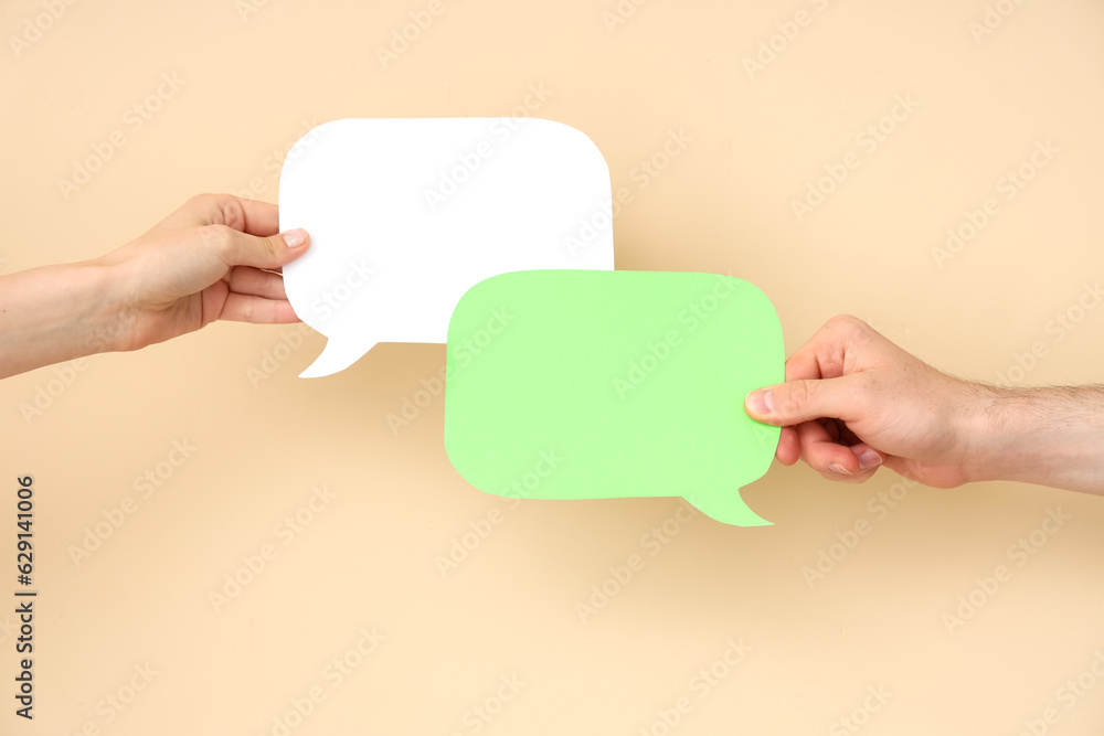 Different hands with speech bubbles on beige background