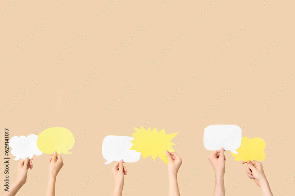 Different hands with speech bubbles on beige background