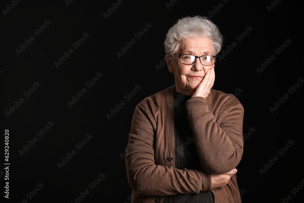 Senior woman in eyeglasses on black background