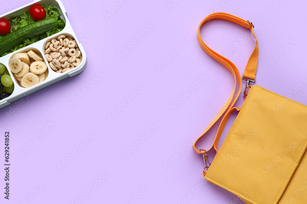 Bag and lunchbox with tasty food on lilac background